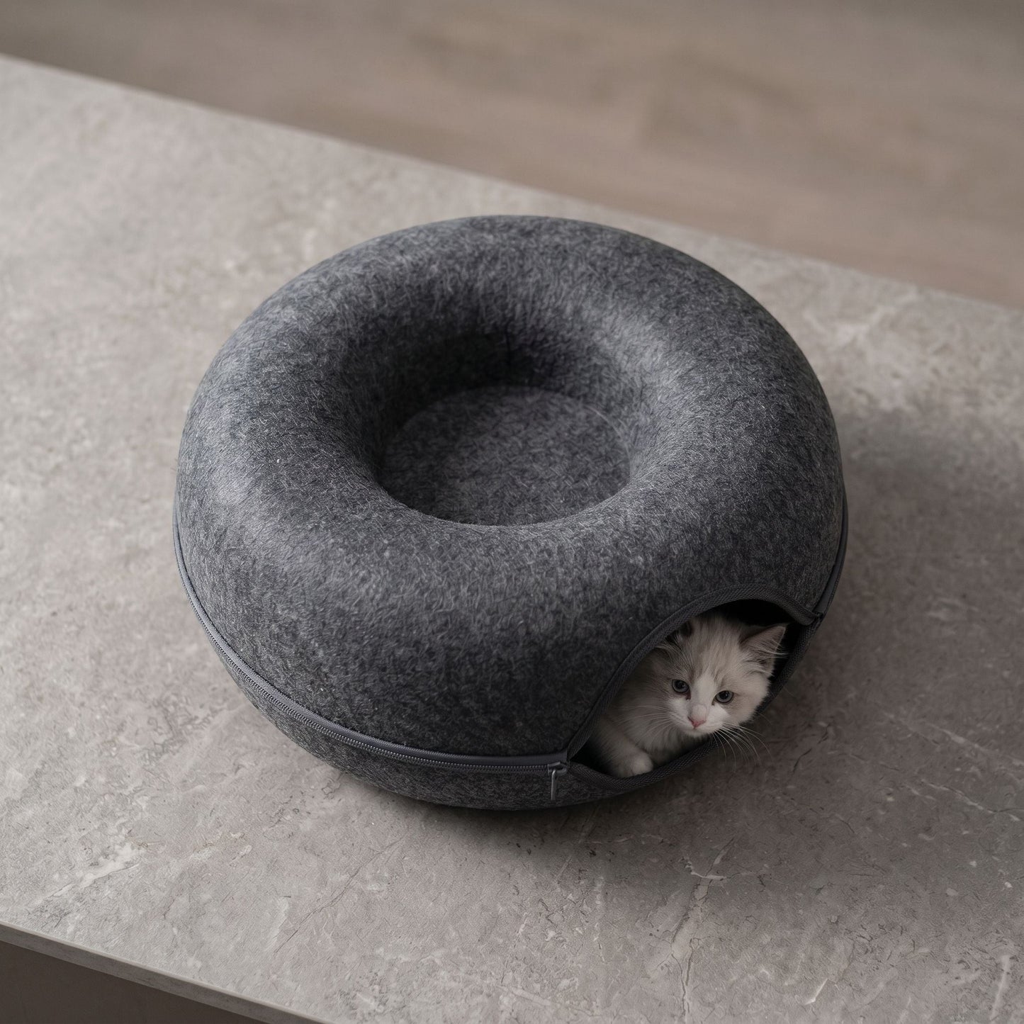 Overhead macro image of felt cat bed on textured stone surface, emphasizing craftsmanship and detailed fiber material.