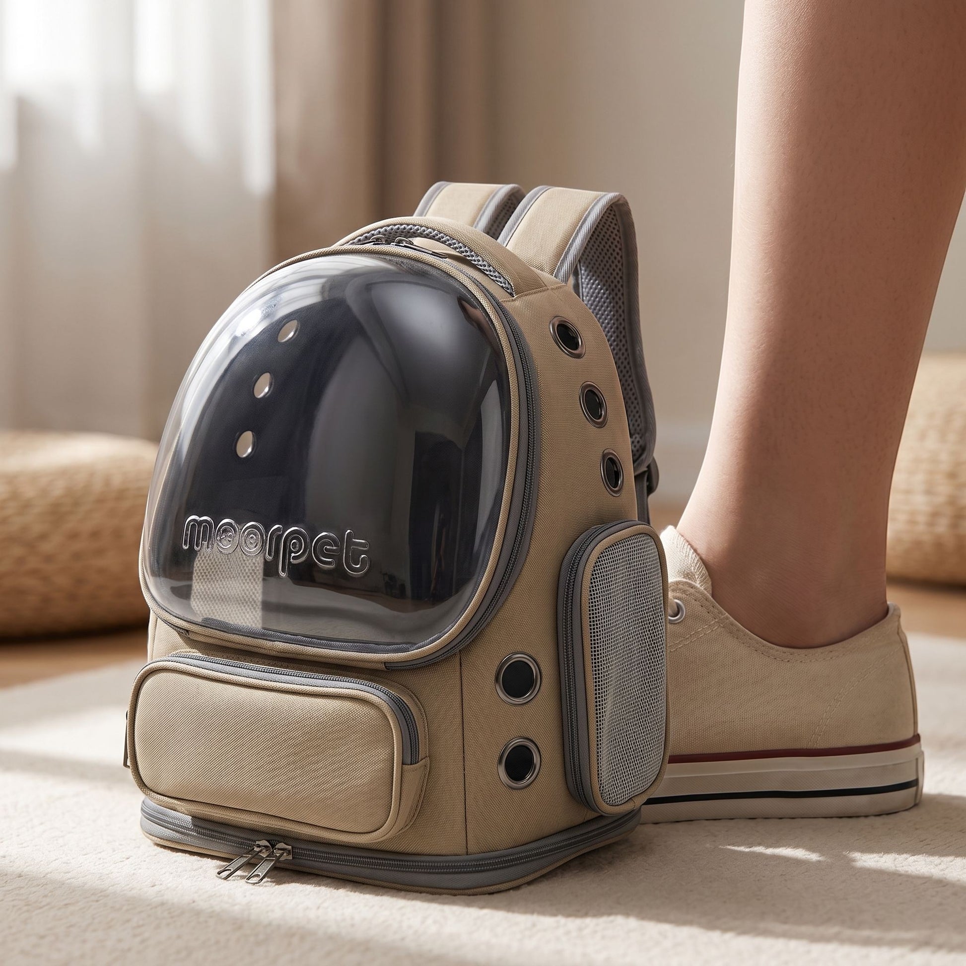Close-up of a small khaki nylon cat carrier backpack highlighting its micro-texture, zipper, and ventilation mesh with a neutral studio background.