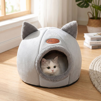 Full view of a small cotton pet bed with a curled-up cat inside, illuminated by daylight, emphasizing the cozy, secure design in a living room setting.