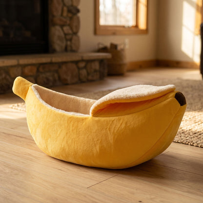 Side view of cozy banana-shaped cat bed on wooden floor, showcasing soft rounded edges and durable fabric.